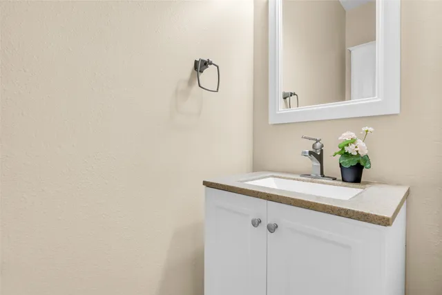a bathroom with a granite countertop sink and a mirror