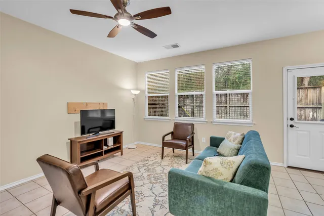 a living room with furniture a flat screen tv and a window