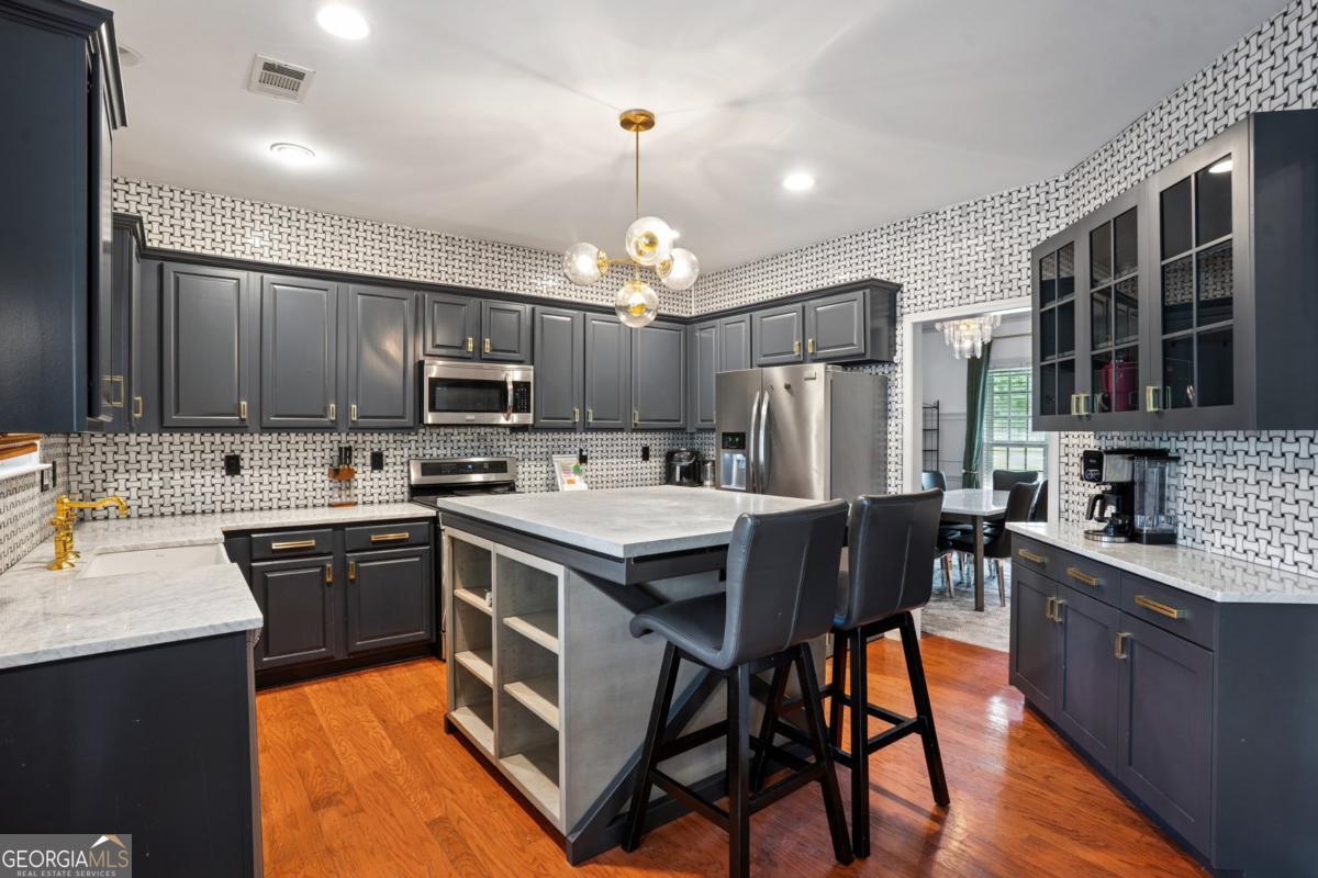 1229 Crescentwood Lane Decatur, GA 30032 - Photo 7 of 25 a kitchen with stainless steel appliances granite countertop a stove top oven a sink dishwasher a dining table and chairs