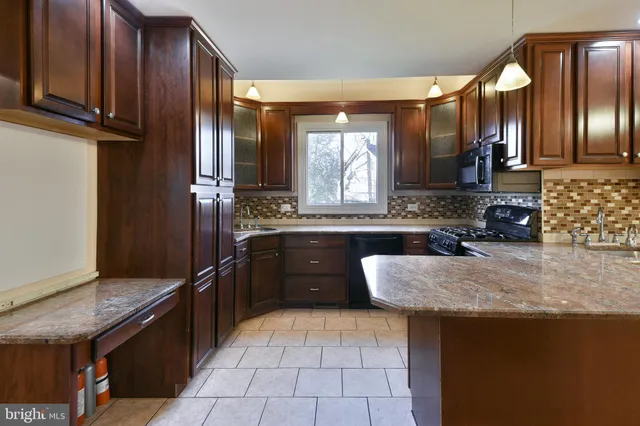 a large kitchen with granite countertop a sink and cabinets