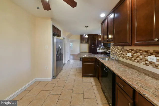 a large kitchen with stainless steel appliances granite countertop a stove a sink and a refrigerator