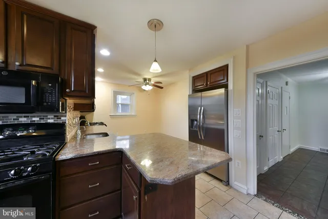 a kitchen with a sink a kitchen island and stainless steel appliances