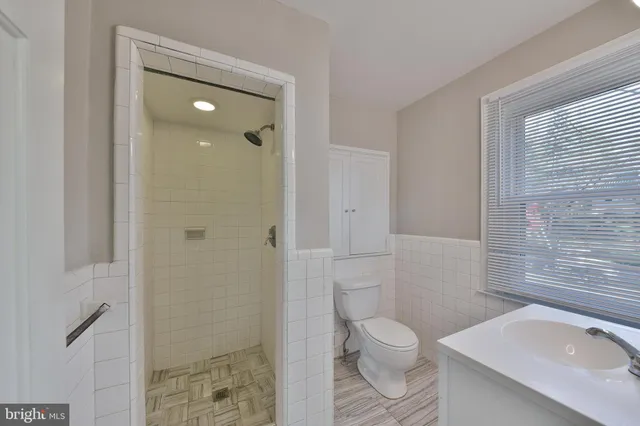 a bathroom with a granite countertop toilet a sink and a shower
