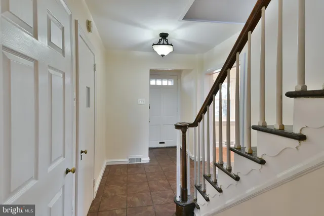a view of staircase with lots of frames on wall and wooden floor
