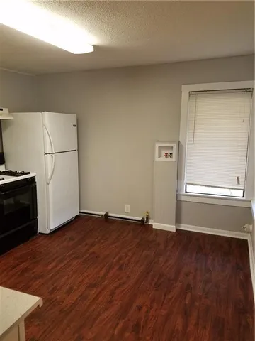 an empty room with wooden floor and cabinet