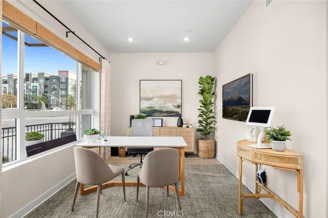 a dining room with furniture large windows and wooden floor