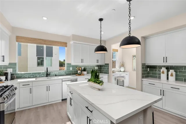 a kitchen with stainless steel appliances kitchen island granite countertop a kitchen island hardwood floor sink stove dining table and chairs