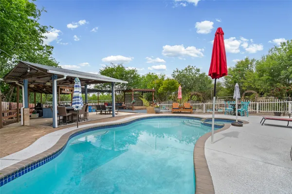 a view of a swimming pool with a patio and a garden