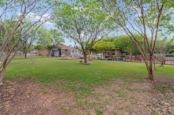 a view of a house with a big yard and large trees