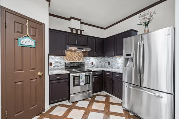 a kitchen with stainless steel appliances granite countertop a refrigerator stove and sink