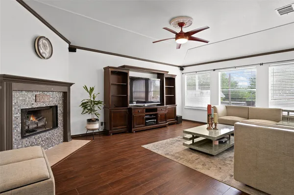 a living room with furniture a flat screen tv and a fireplace
