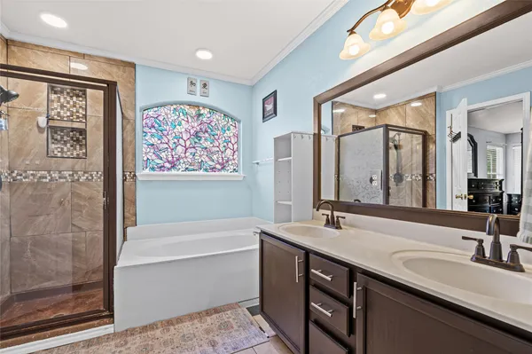 a bathroom with a double vanity sink large mirror and a bathtub