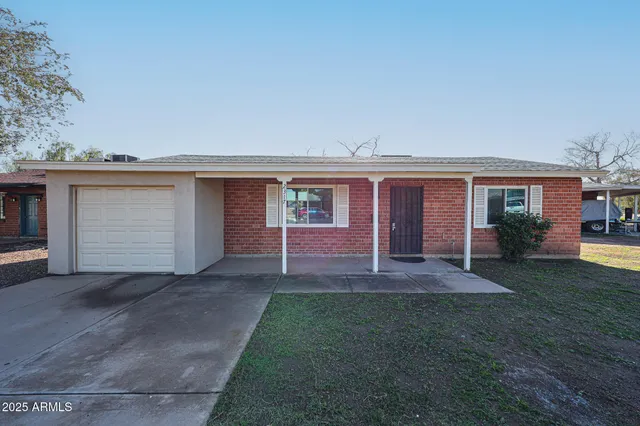 front view of a house with a yard and an outdoor seating