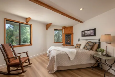 a bedroom with a bed a chair and a large window