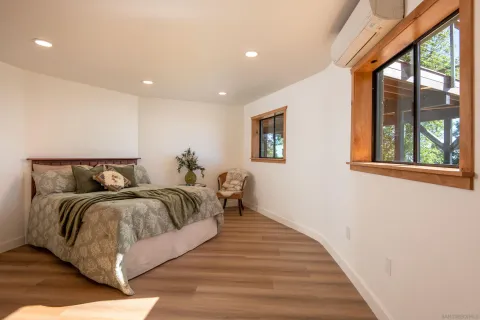 a spacious bedroom with a bed and wooden floor