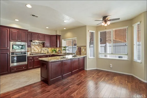 a kitchen with stainless steel appliances granite countertop a sink stove and cabinets
