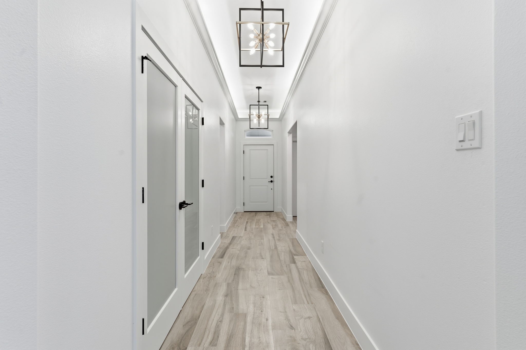 5227 Sunshine Point Willis, TX 77318 - Photo 31 of 33 THIS ENTRY HALL SHOWCASES A FEW EXAMPLES OF THE CUSTOM LIGHTING FEATURES THROUGHOUT THIS ONE STORY BEAUTY! THREE BEDROOMS ARE THE RIGHT HERE UPON ENTRY IN THIS PICTURE. THE LAUNDRY IS WELL POSITONED NEAR THE BULK OF THE LAUNDRY AS WELL. THE 2 CAR GARAGE ON THE LEFT HERE JUST BEFORE THE DOUBLE DOORS TO THE STUDY. NOTE FLOOR PLAN AT THE END OF THE PICTURES FOR A BETTER EXAMPLE OF THE LAYOUT.