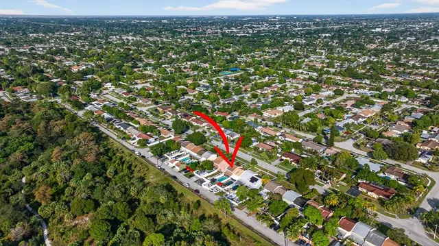 an aerial view of residential houses with outdoor space and trees