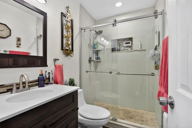 a bathroom with a sink a toilet and shower