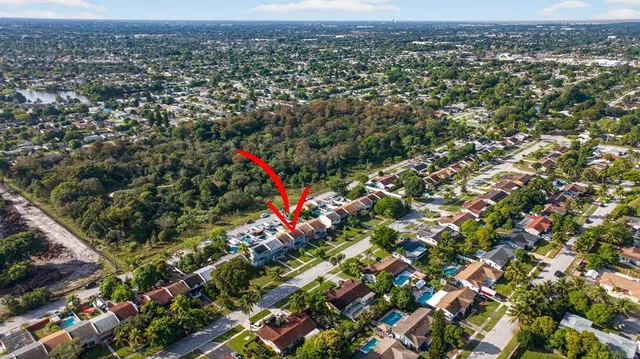 an aerial view of residential houses with city and outdoor space