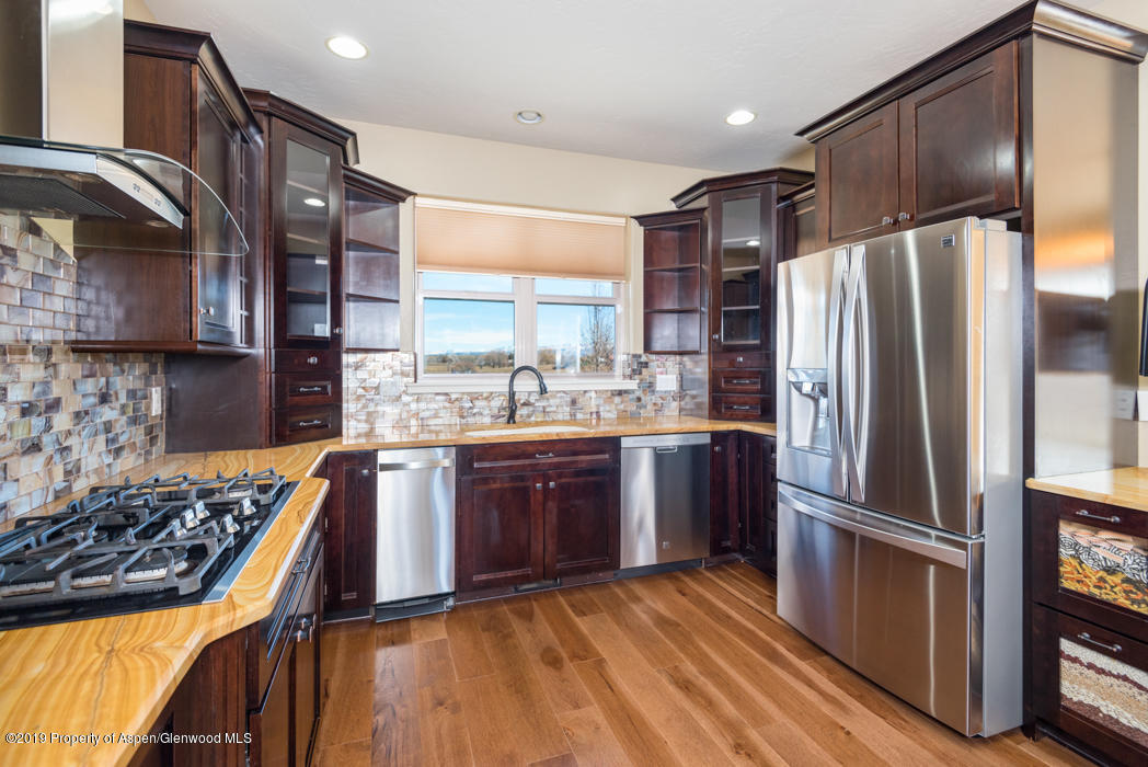 1317 East 17th Street Rifle, CO 81650 - Photo 12 of 57 a kitchen with stainless steel appliances granite countertop a refrigerator a sink dishwasher a stove with wooden floor and cabinets
