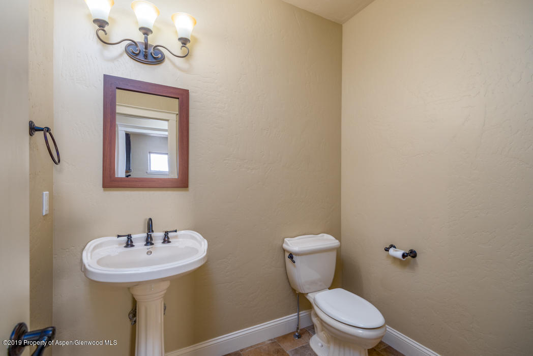 1317 East 17th Street Rifle, CO 81650 - Photo 14 of 57 a bathroom with a toilet sink and mirror