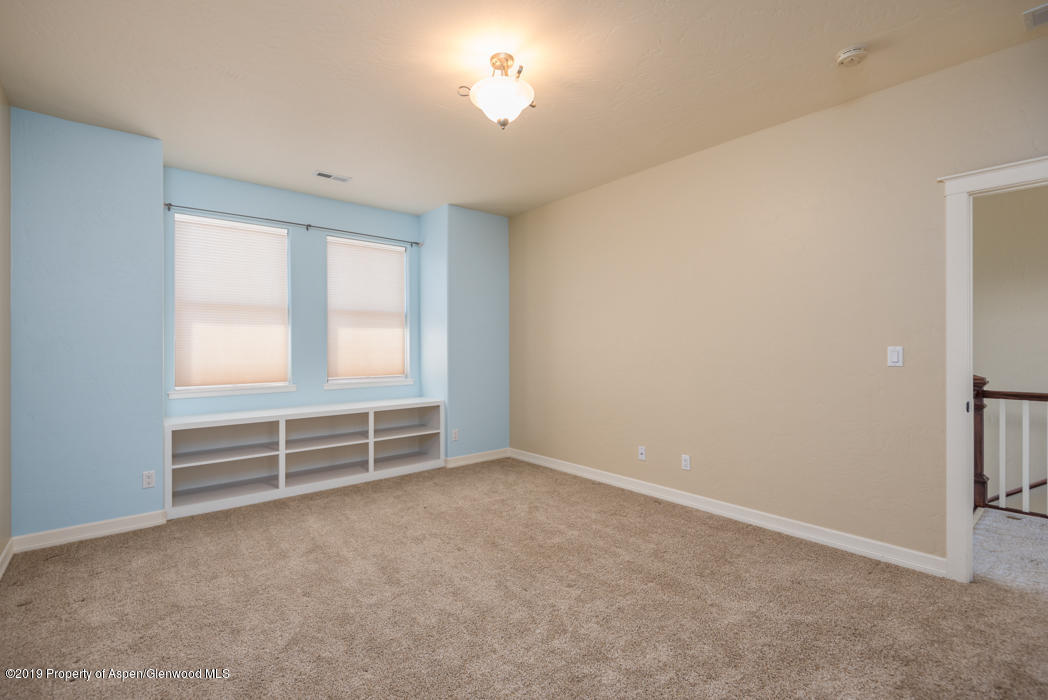1317 East 17th Street Rifle, CO 81650 - Photo 23 of 57 an empty room with windows and chandelier fan