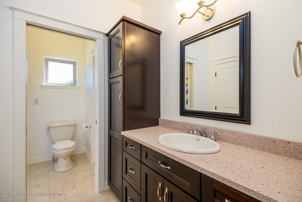 1317 East 17th Street Rifle, CO 81650 - Photo 27 of 57 a bathroom with a granite countertop sink toilet and mirror