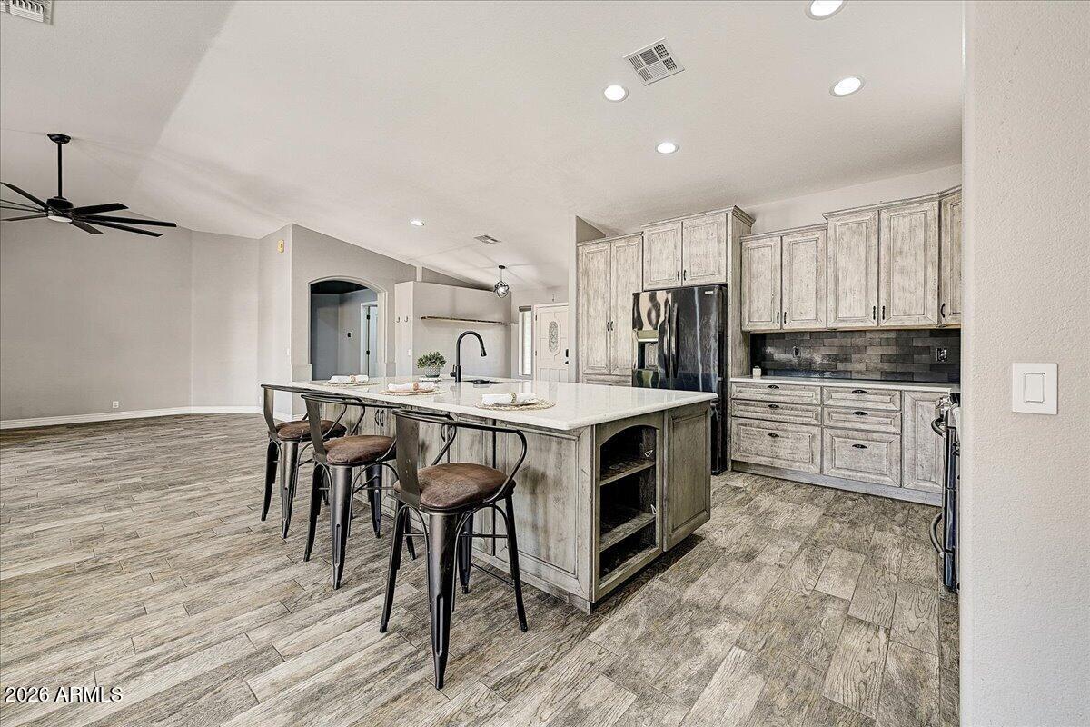 7624 North Citrus Road Waddell, AZ 85355 - Photo 14 of 57 a kitchen with kitchen island a stove a table and chairs in it