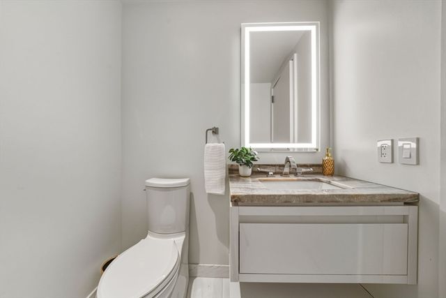 a bedroom with a bed and a lamp on dresser