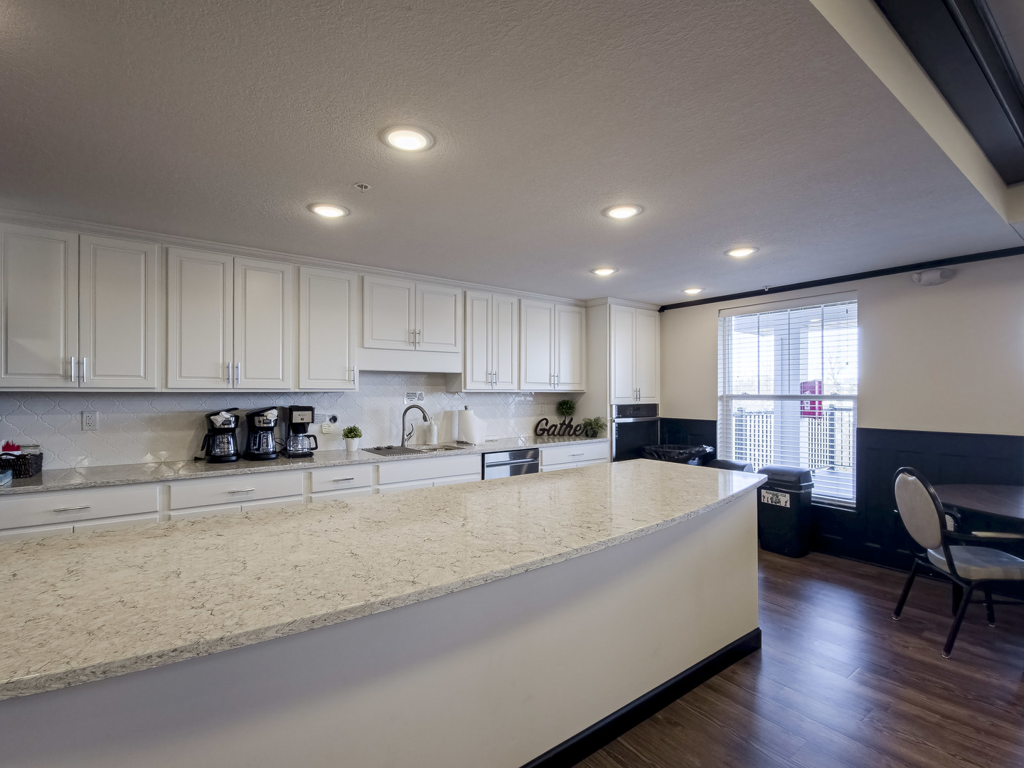2592 Middle Road, Unit 313 Bettendorf, IA 52722 - Photo 42 of 52 a large white kitchen with wooden floor and cabinetry