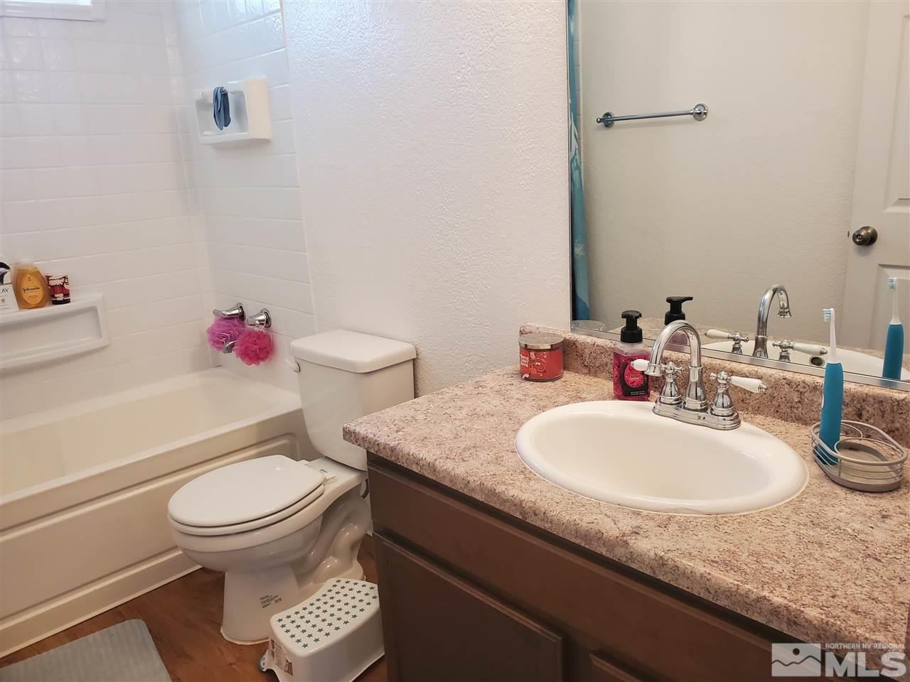 7610 Lytton Road Reno, NV 89506 - Photo 10 of 17 a bathroom with a granite countertop toilet sink and mirror