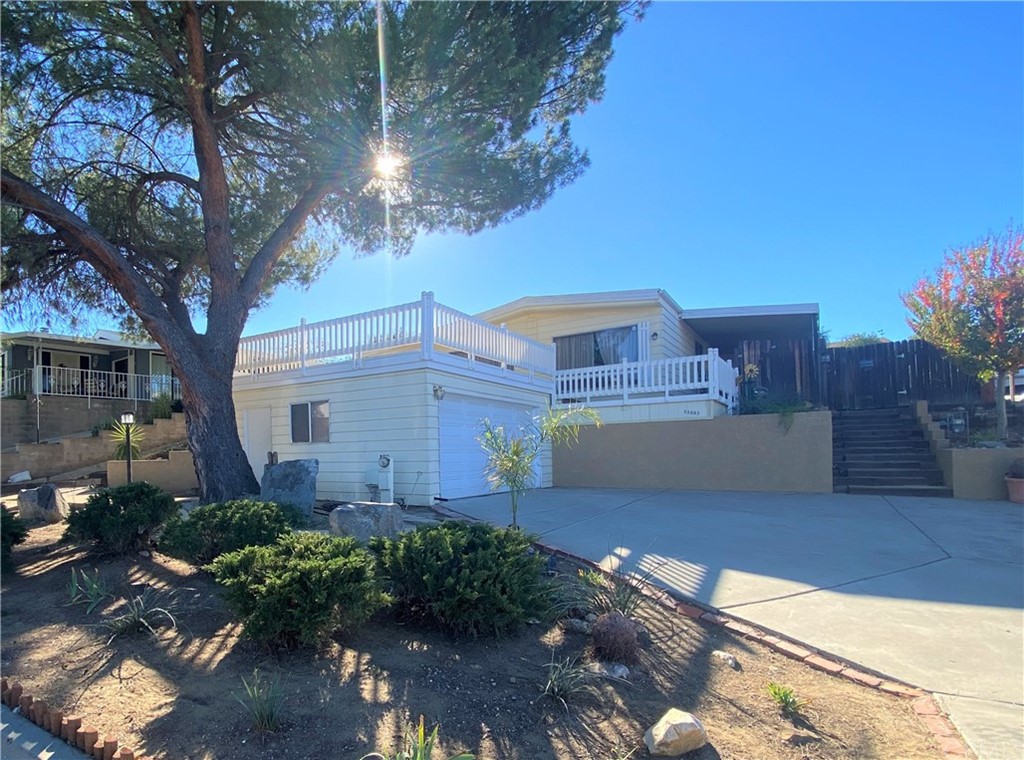 a view of a house with a tree and a yard