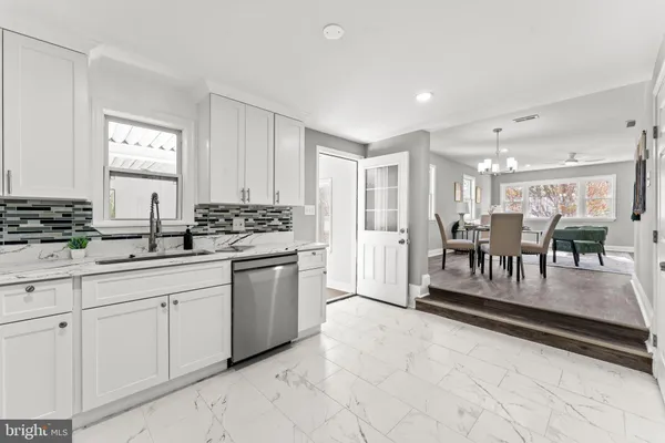 a kitchen with white cabinets and sink