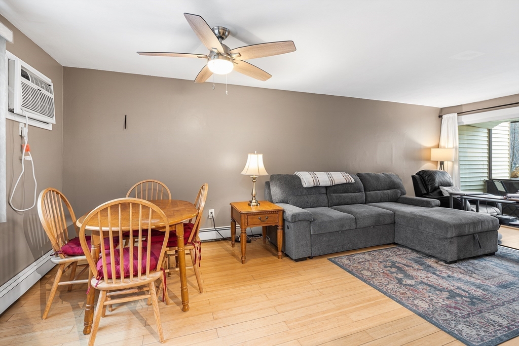 17 Powderhouse Court, Unit 17 Amesbury, MA 01913 - Photo 4 of 13 a living room with furniture a dining table and a chandelier