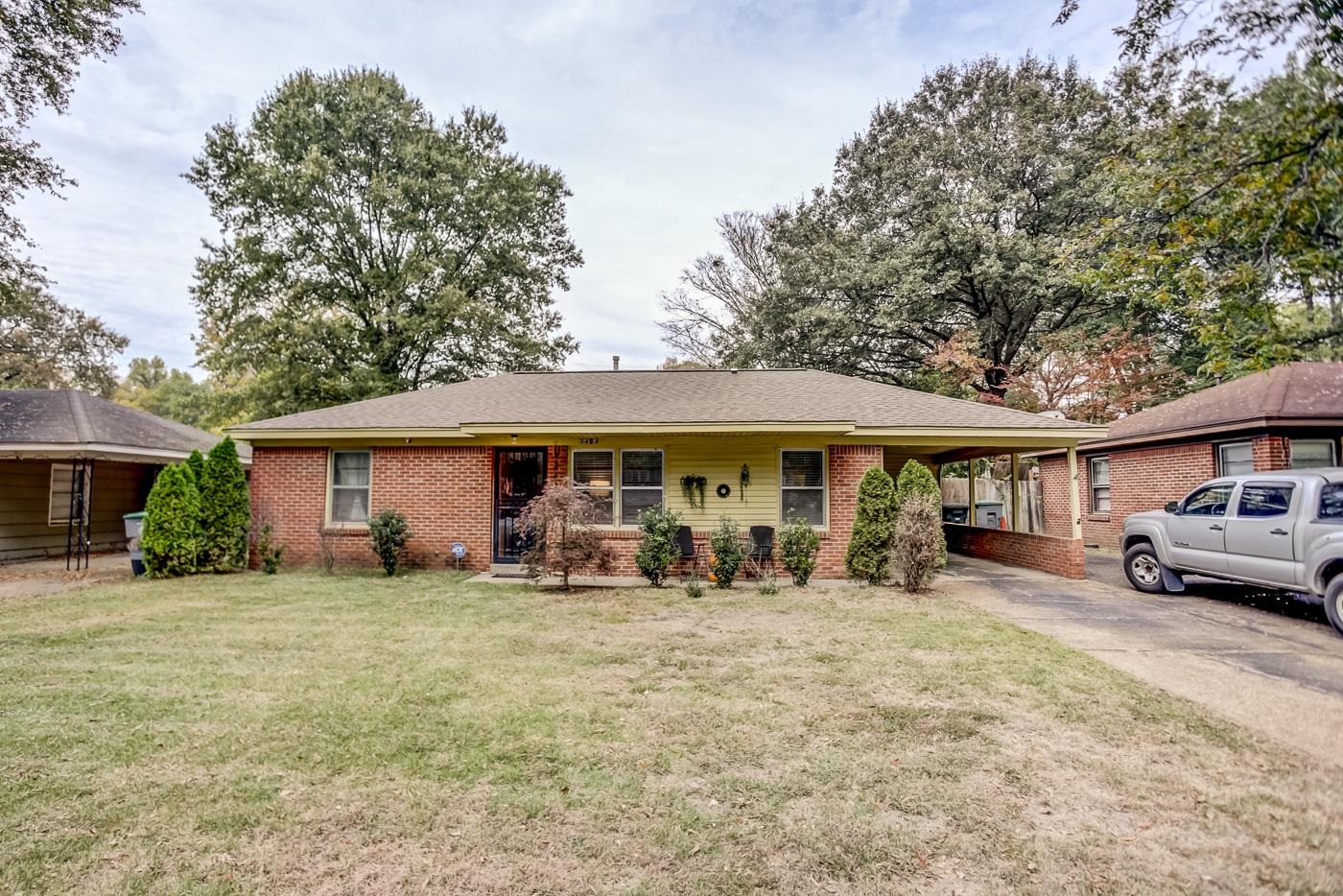 4464 Helene Road Memphis, TN 38117 - Photo 3 of 27 a blue house covered with tall trees
