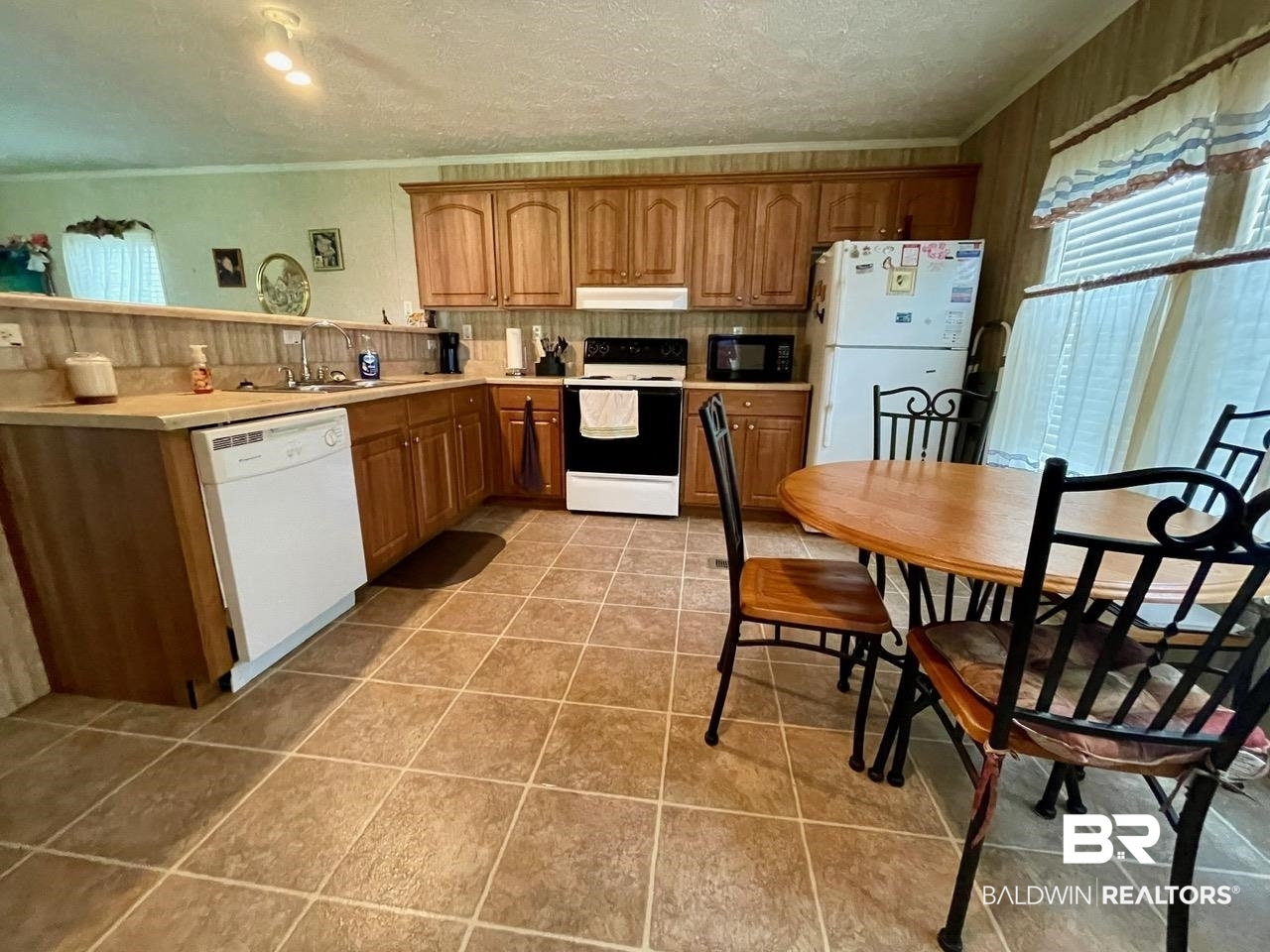 15338 Windbigler Drive Foley, AL 36535 - Photo 16 of 28 Kitchen with white appliances, light tile patterned floors, sink, and a textured ceiling