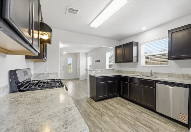 a large kitchen with stainless steel appliances granite countertop a stove and a sink