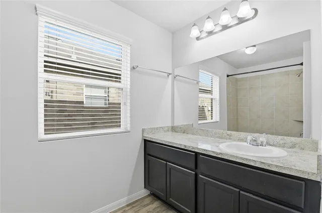 a bathroom with a granite countertop sink a mirror and a window