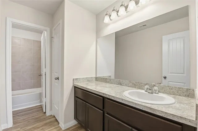 a bathroom with a granite countertop sink and a mirror