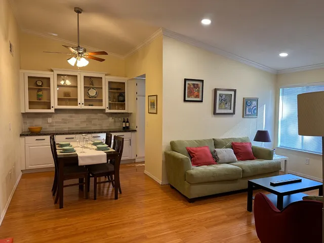 a living room with furniture a dining table and chairs with wooden floor