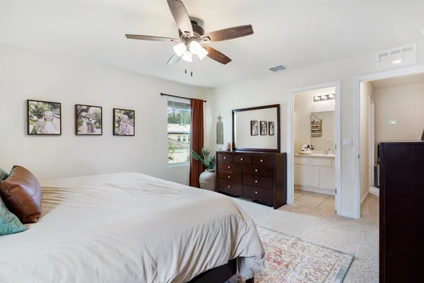 a bedroom with a bed and a mirror on dresser