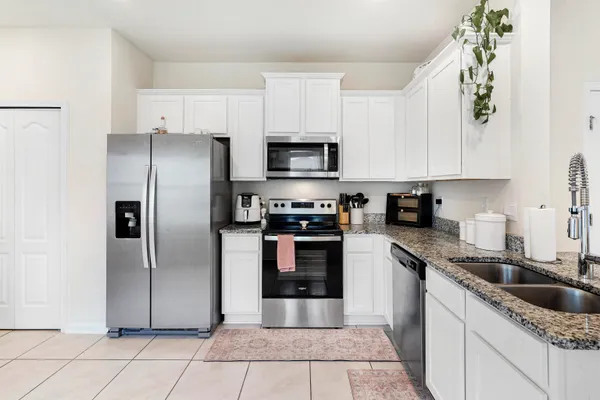 a kitchen with granite countertop a refrigerator and a sink