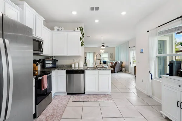 a kitchen with stainless steel appliances granite countertop a refrigerator and a sink