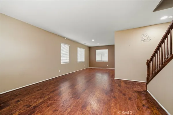 an empty room with wooden floor and a window