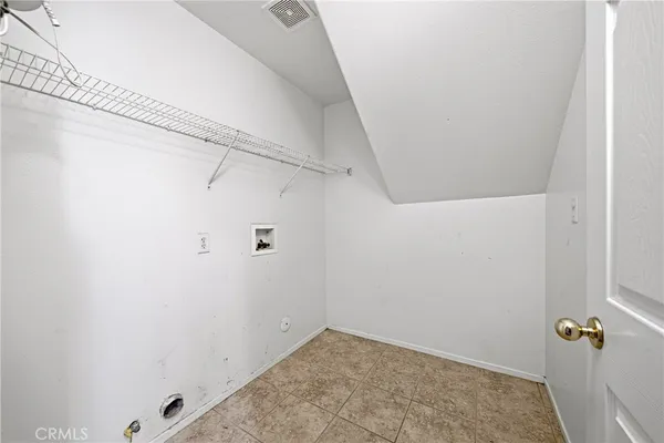 an empty room with a chandelier fan and windows