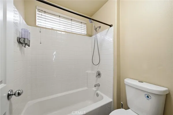 an empty room with ceiling fan and window