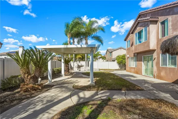 a view of a house with backyard and sitting area