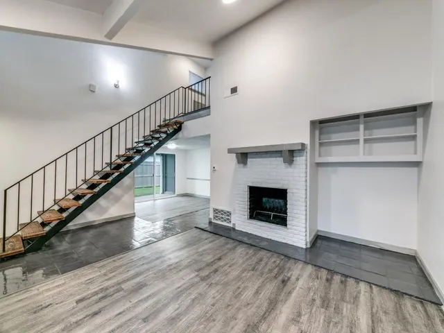 a view of a livingroom with wooden floor and a fireplace