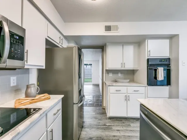 a kitchen with a sink dishwasher a refrigerator and cabinets
